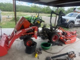Compact tractor dismantled for repair with parts laid out